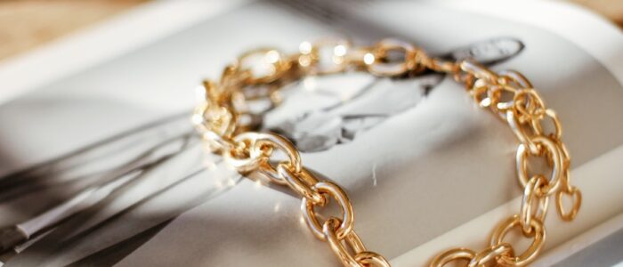 a gold chain bracelet sitting on top of a magazine