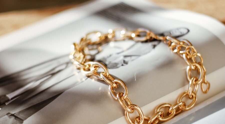 a gold chain bracelet sitting on top of a magazine